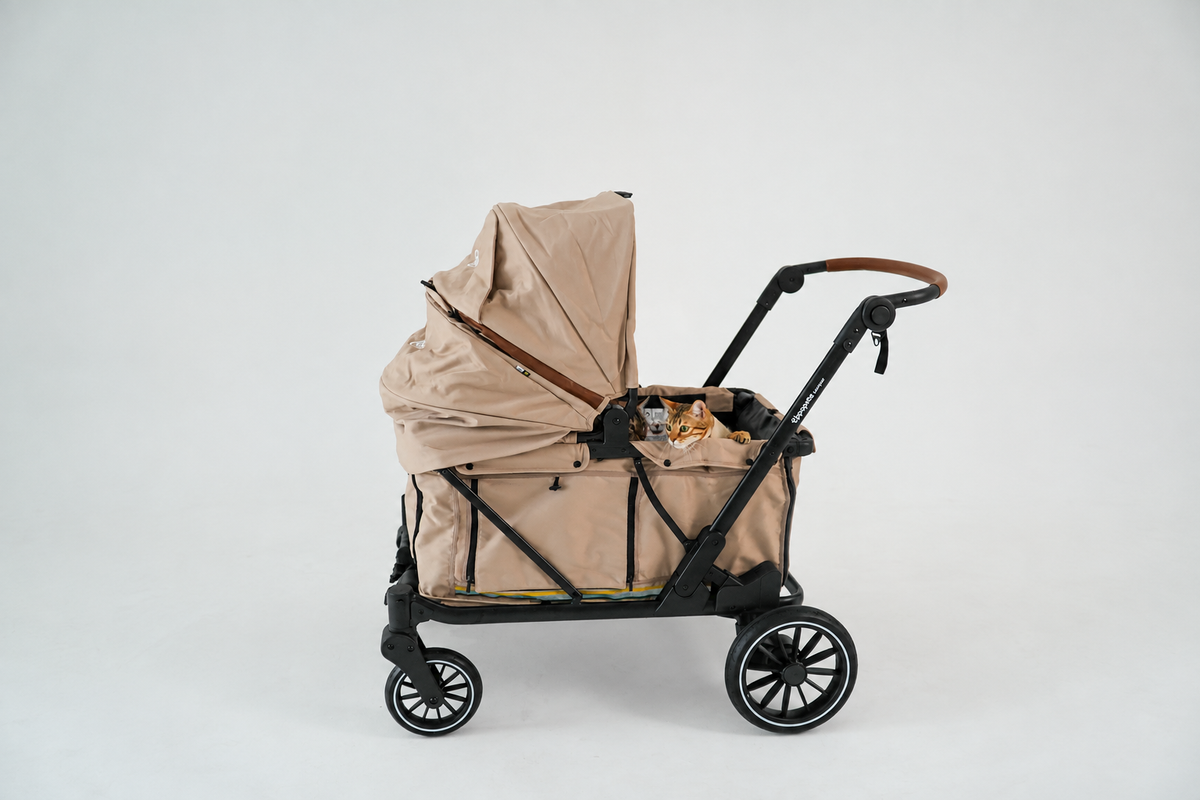 Beige Uppapets Camper Max pet stroller with black frame, large canopy, side storage bag and brown handle accents on a white background.